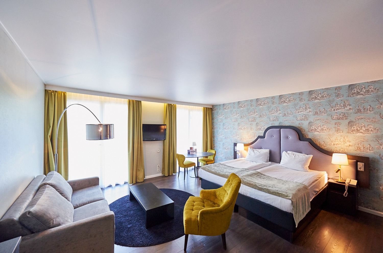 Contemporary hotel bedroom with yellow accents and modern decor.