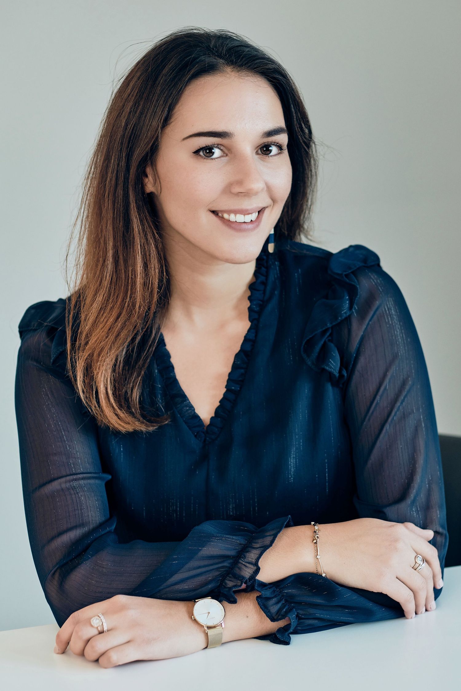 Professional portrait series in black blouse against neutral background.
