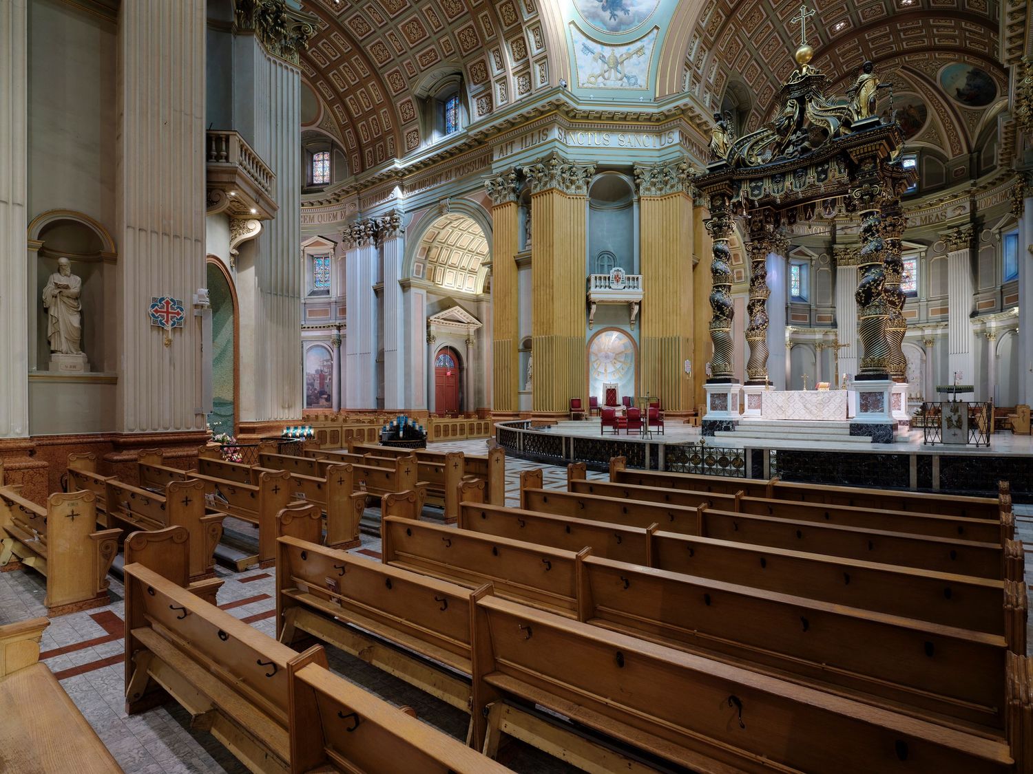Grand cathedral interior with wooden pews, ornate columns, and elegant arched ceilings in a historic church.