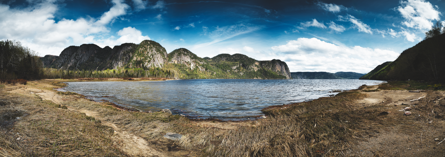 Dramatic mountain landscape with rugged peaks and cliffs against a cloudy sky.