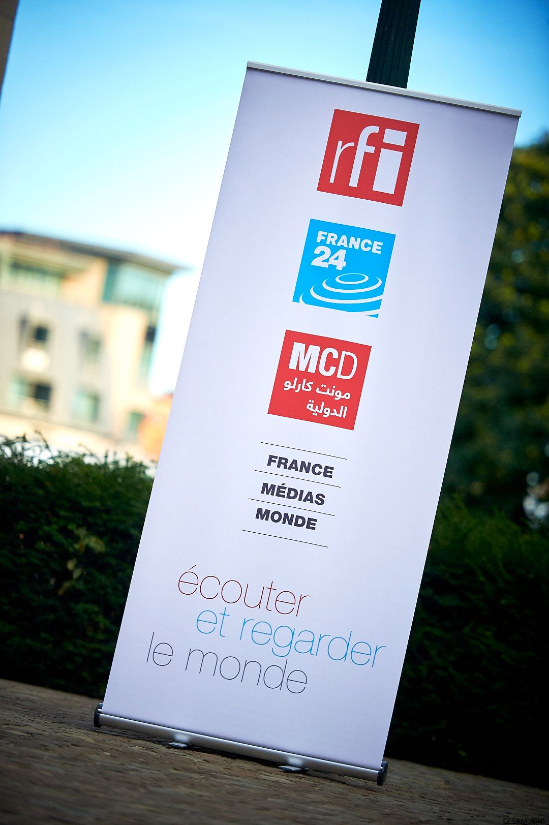 RFI France 24 promotional banner stand with French media branding outdoors.