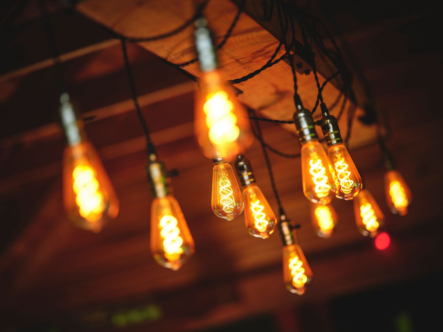 Vintage-style Edison bulb string lights glowing warmly in darkness creating an ambient atmosphere.