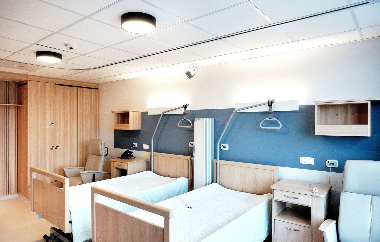 Hospital room panorama showing medical bed, equipment and large exterior windows.