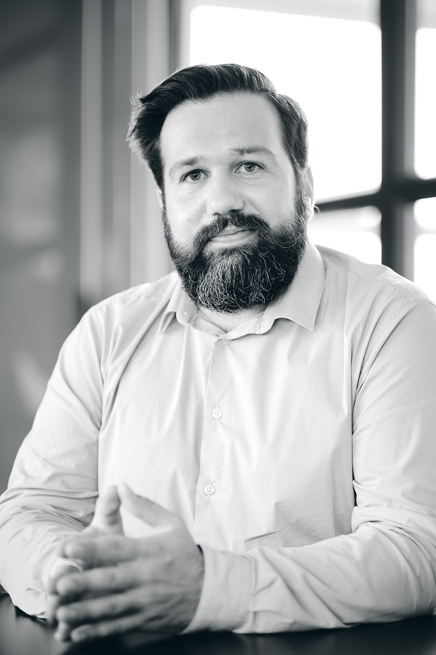 Black and white portraits of person in white shirt against window background.