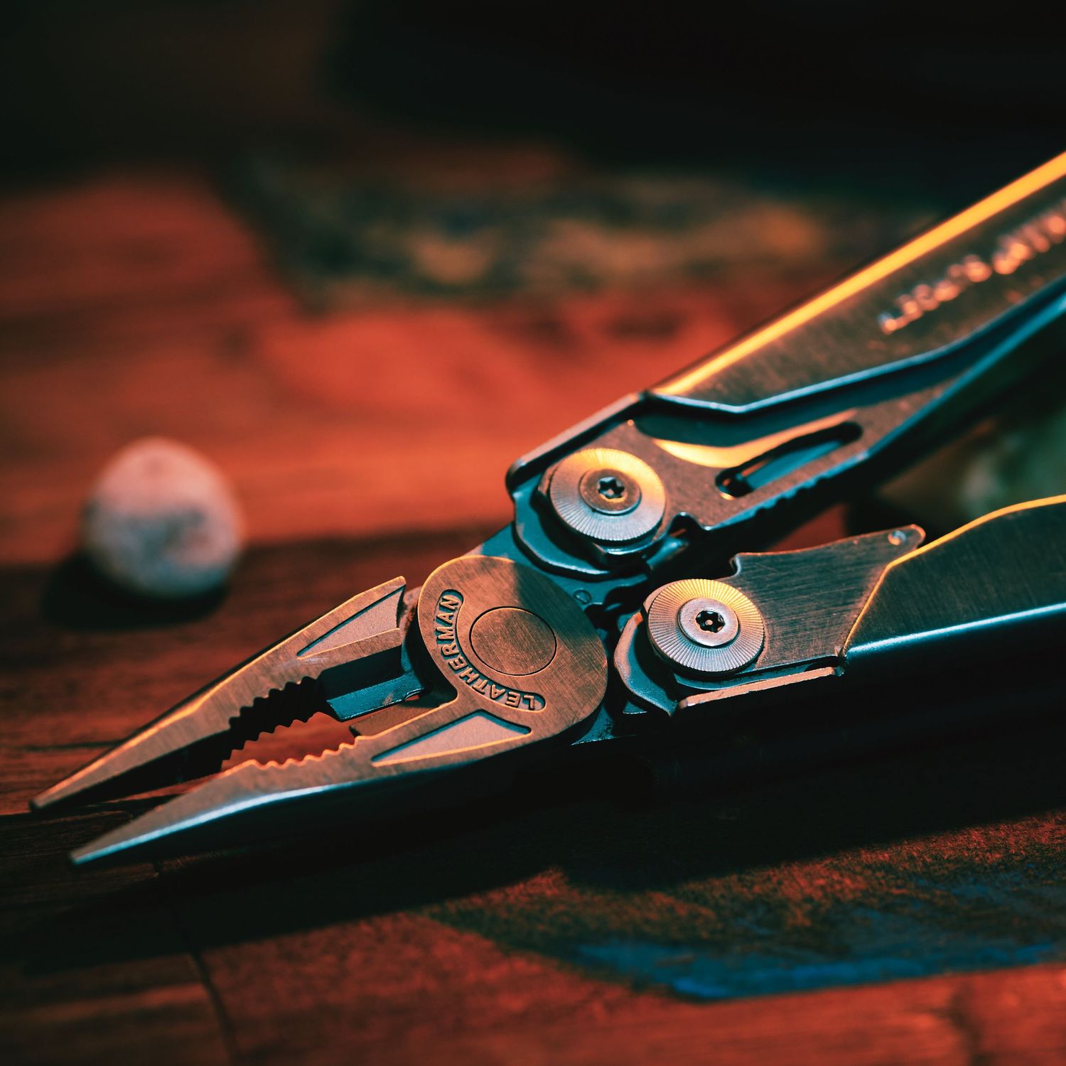 Detailed macro shot of metal pliers or scissors against a red-tinted background.