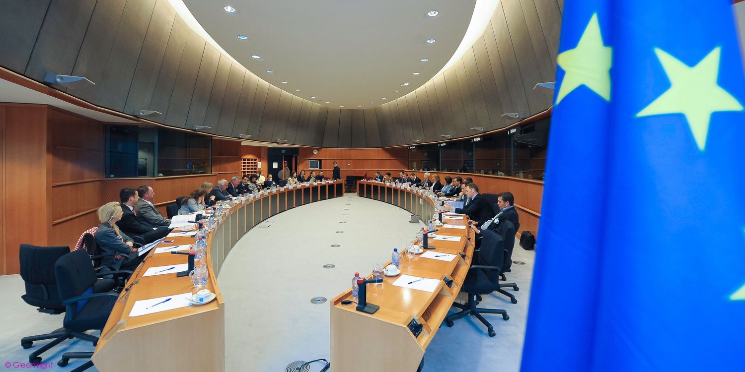 Modern conference room with EU flags and curved ceiling design.