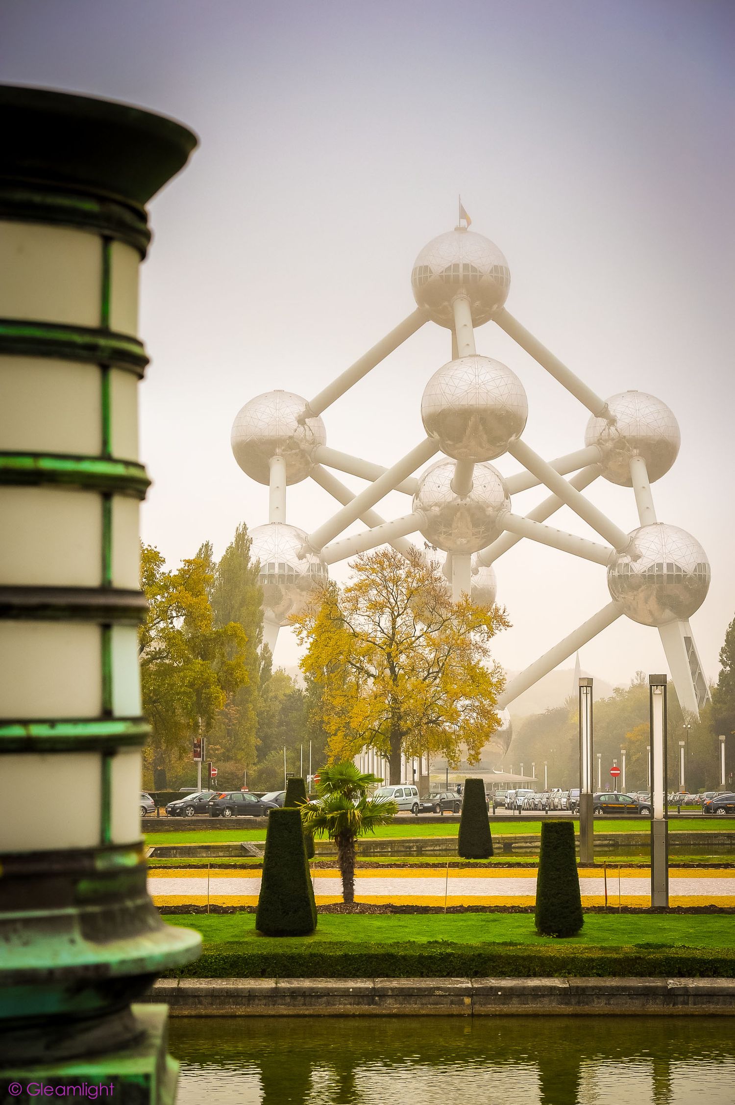 The Atomium monument in Brussels on a foggy autumn day with fall foliage.