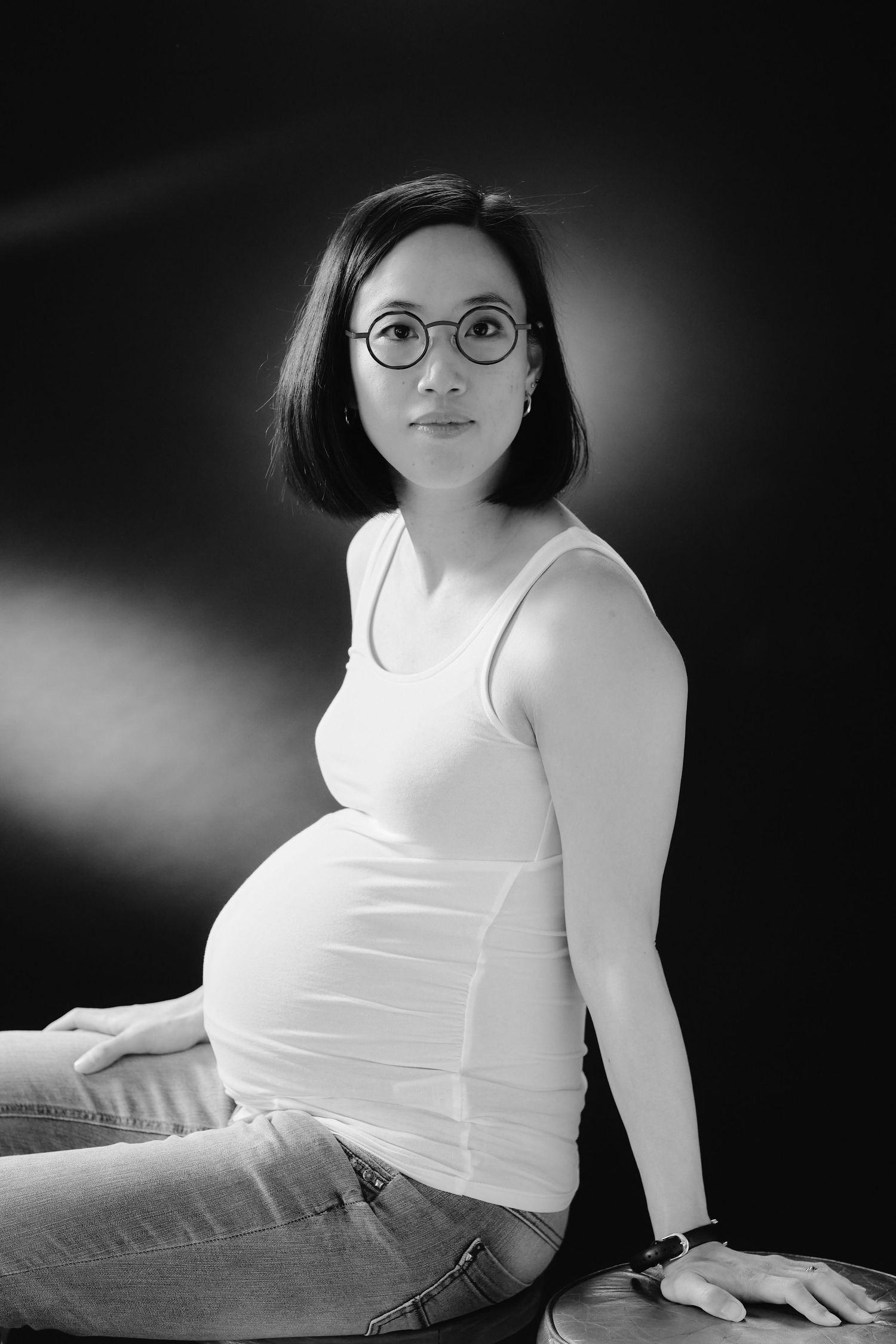 Artistic black and white portraits in casual attire against dark backdrop.