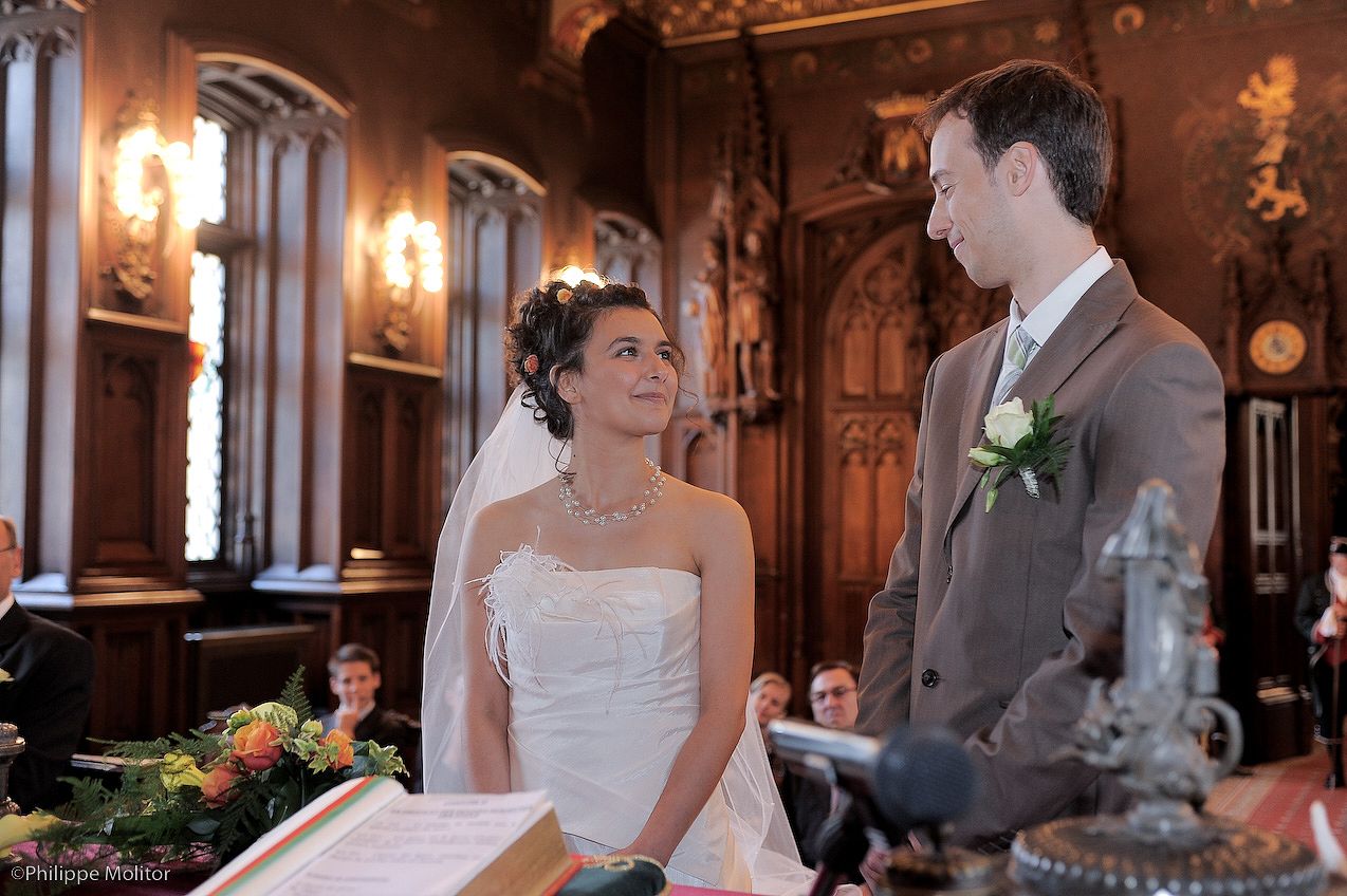 Bride and groom exchanging vows at elegant wood-paneled wedding ceremony venue.