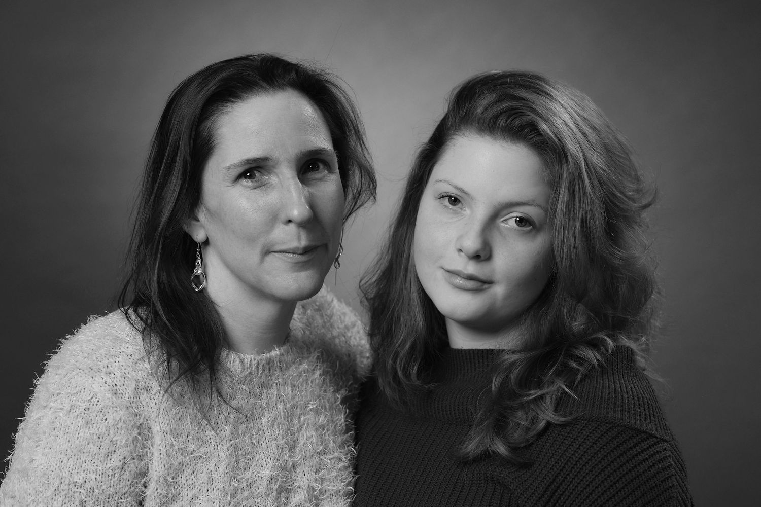 Studio portraits in black and white with soft lighting and textured clothing.