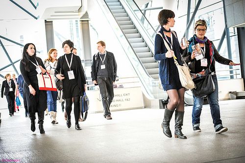 People walking through a modern office building with white interior and glass walls.