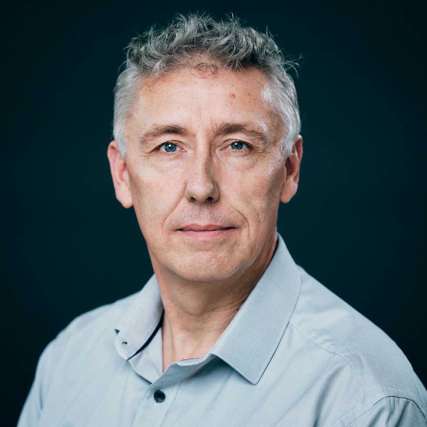 Professional headshot series against dark background wearing light colored shirt.
