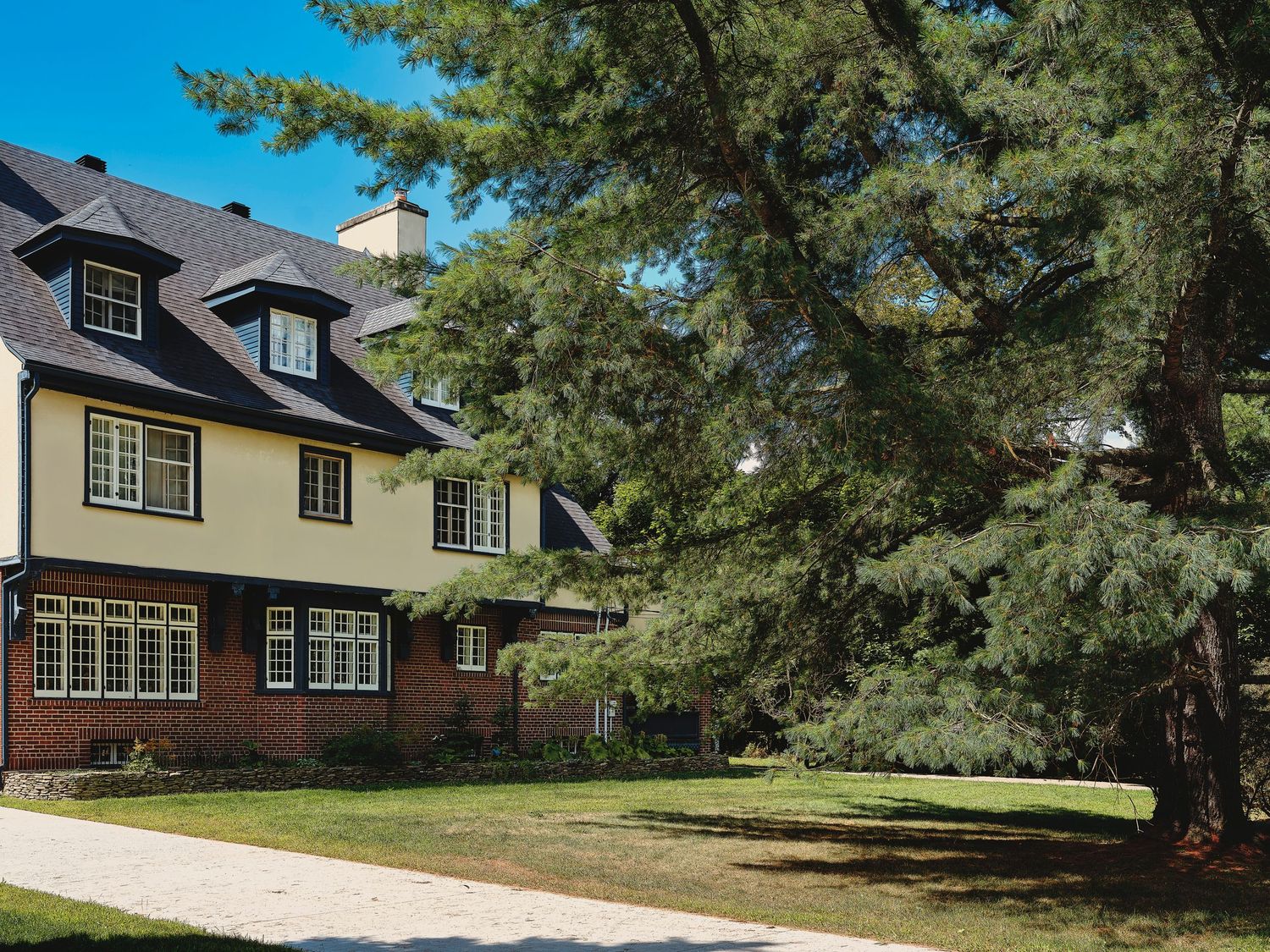 Row of large suburban homes with mature trees and well-maintained lawns.