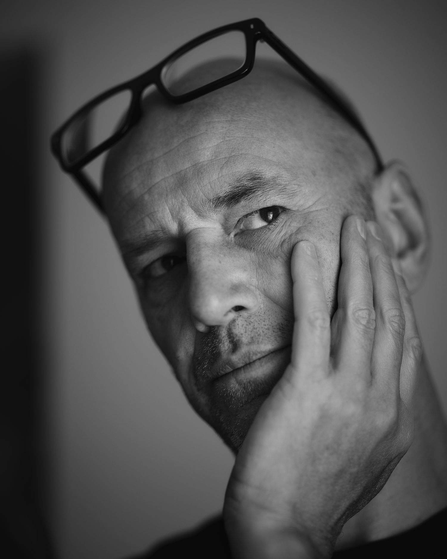 Dramatic black and white portrait sequence showing a contemplative expression in dark lighting.