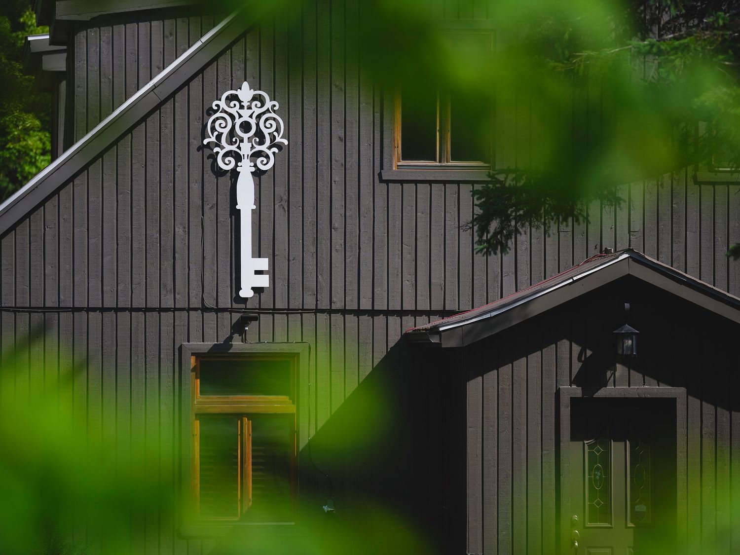 Dark gray wooden buildings with decorative white snowflake designs mounted on the exterior walls.