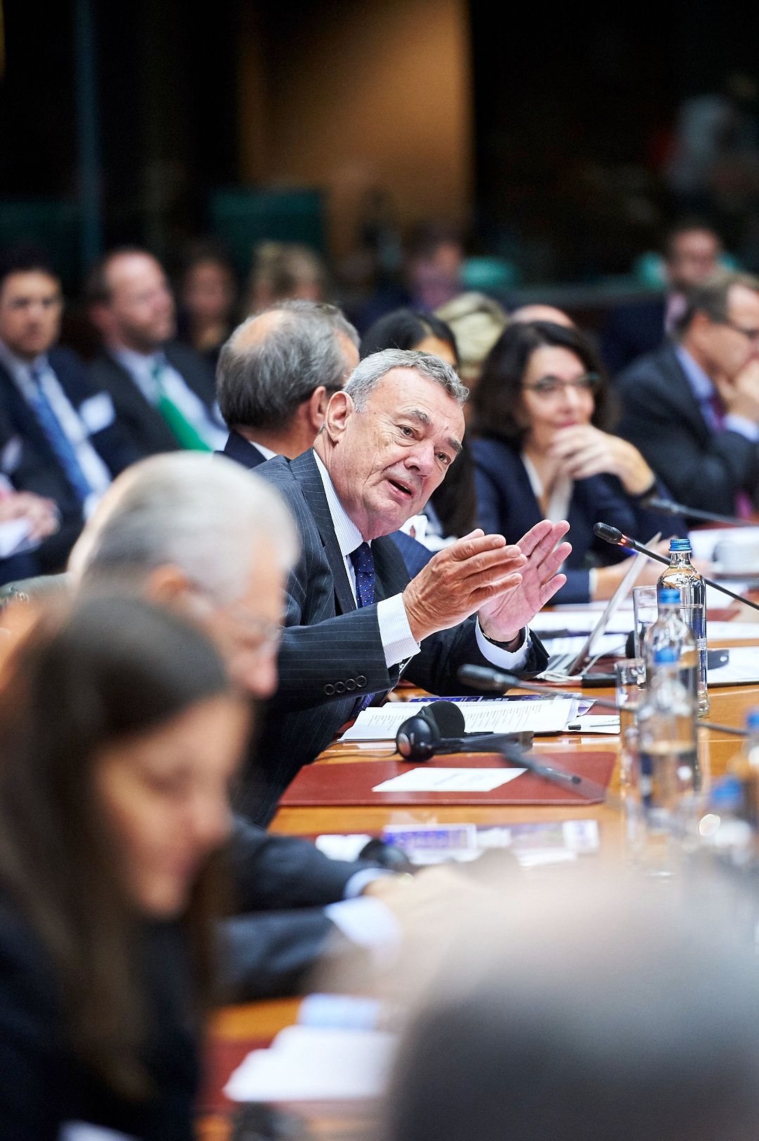 Business executives seated at a conference table during a corporate meeting.