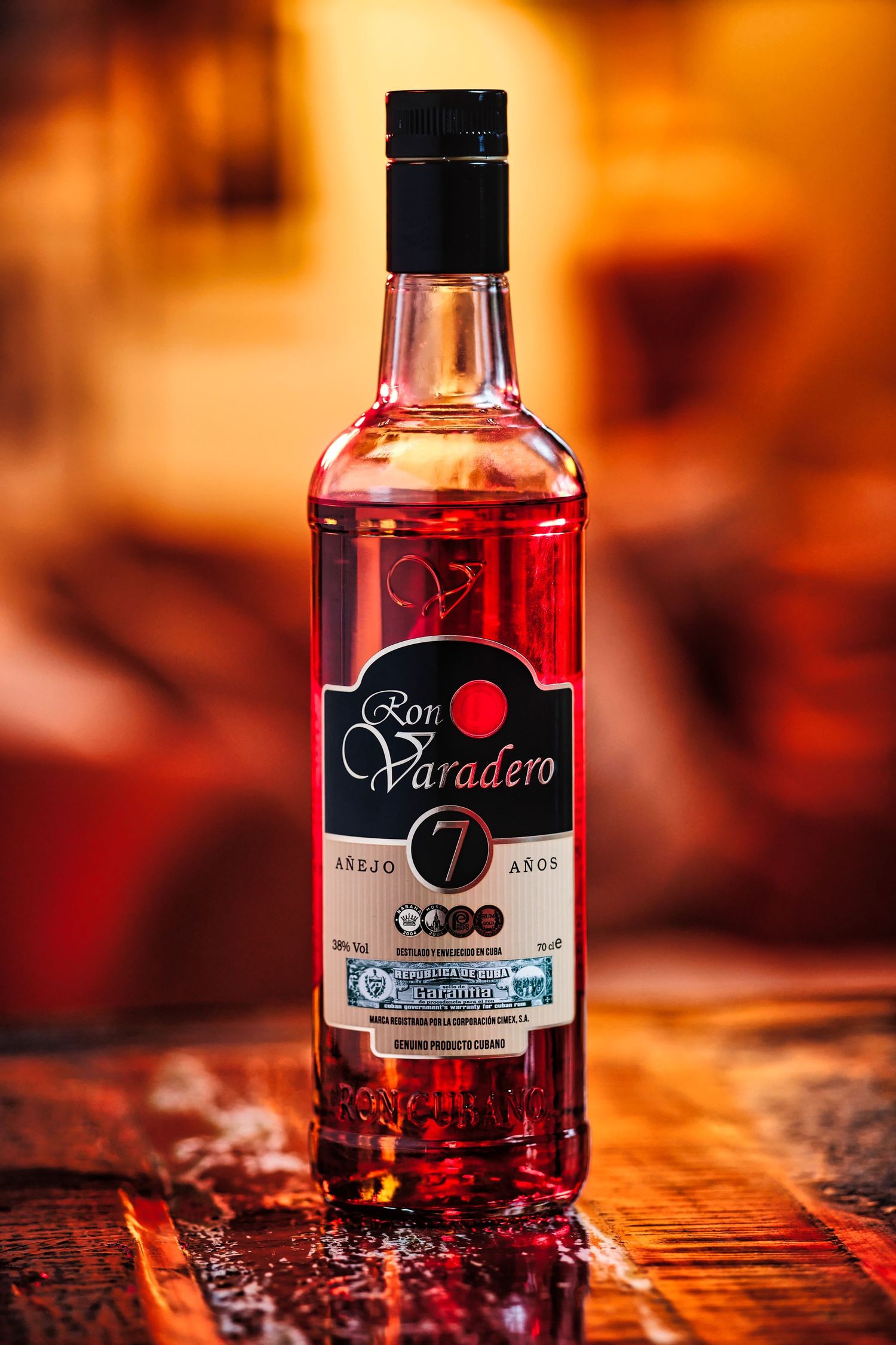 Bottles of Paradero rum displayed on textured surface in warm orange lighting.