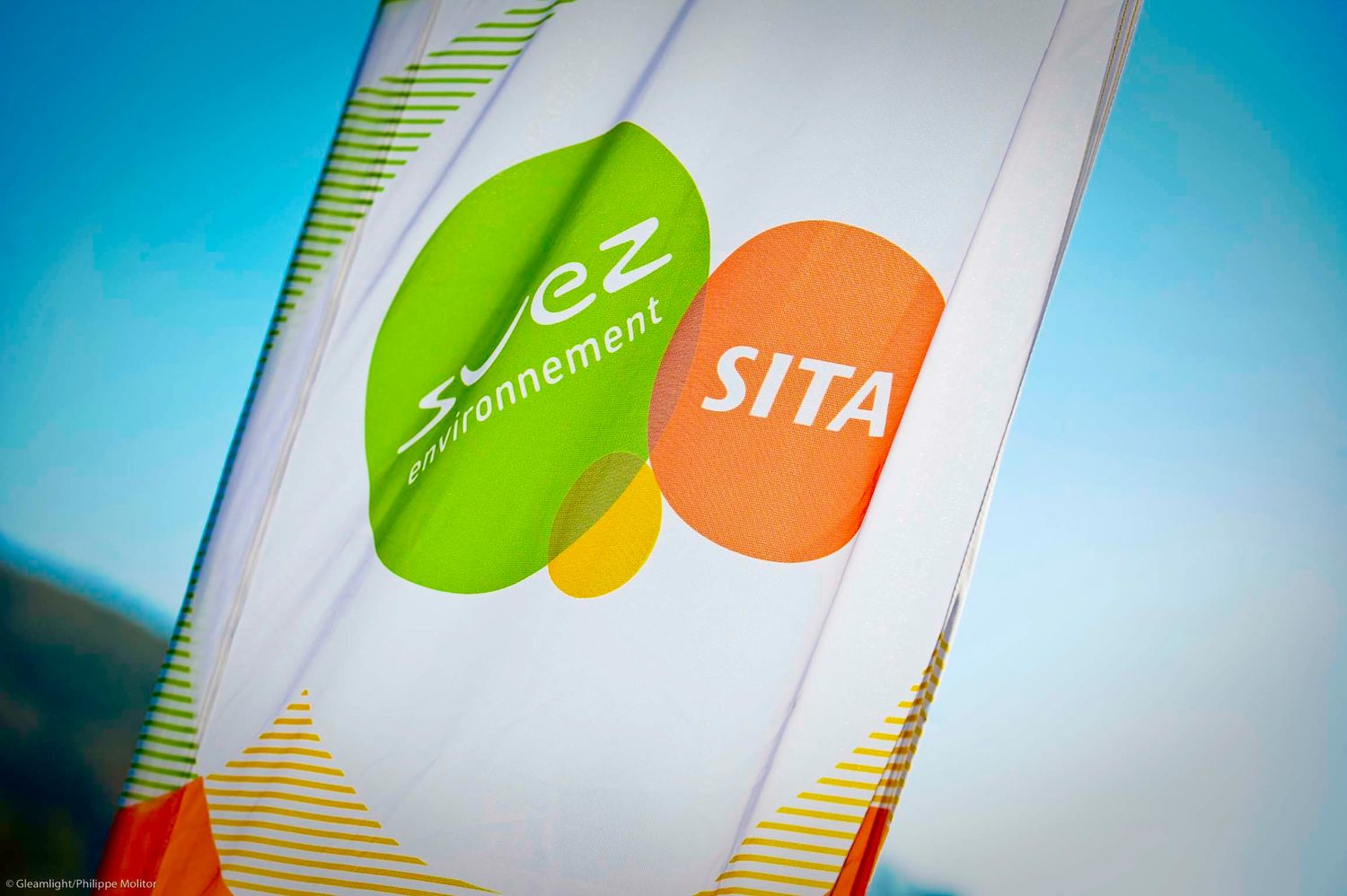Colorful corporate branding elements with green and orange shapes on white background.