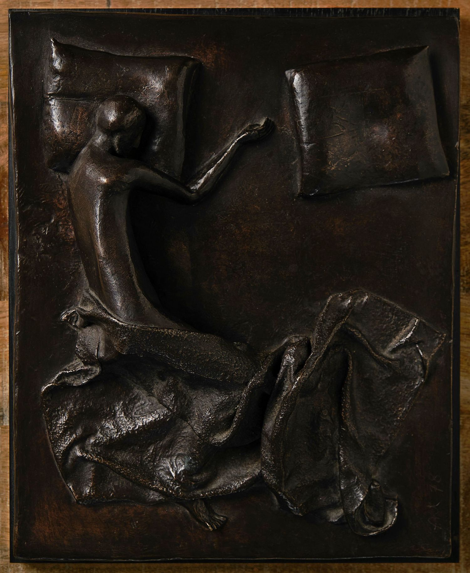 Dark textured metal relief panels displayed in sequence with abstract forms.