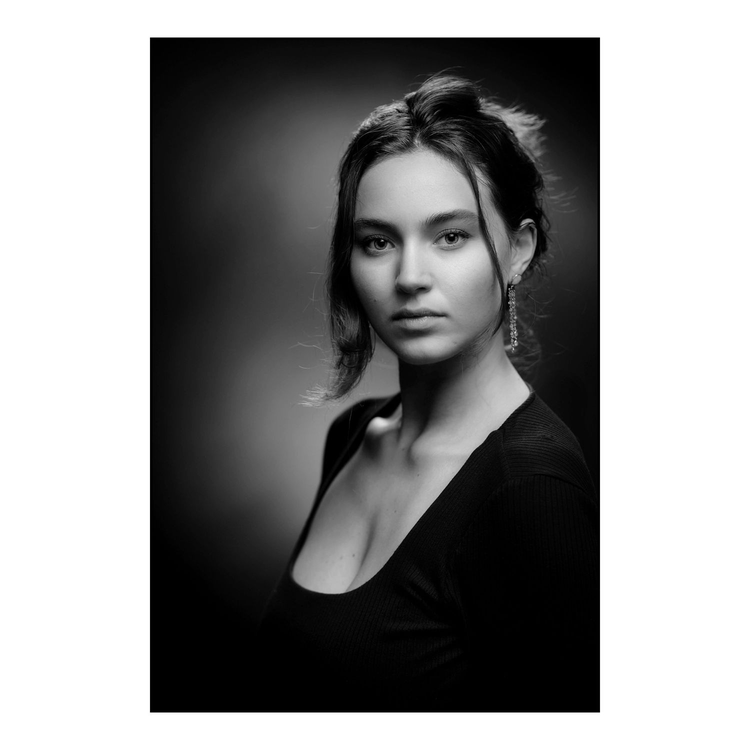 Close-up black and white portrait showcasing intense side lighting and emotional depth.