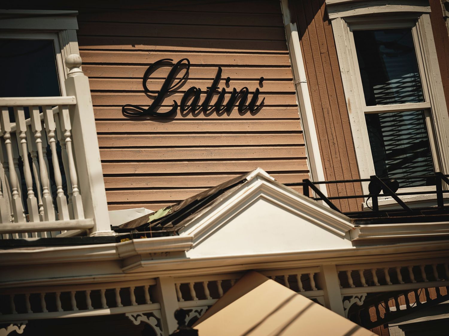 Exterior view of an upscale restaurant with traditional brown siding and white trim details.