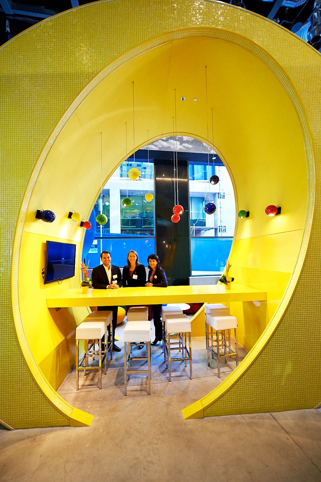 Modern office space featuring circular yellow pod meeting rooms with contemporary design.