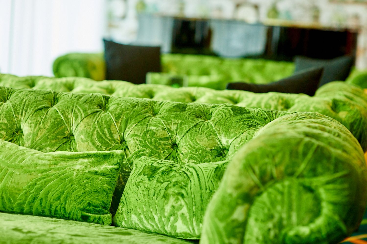 Row of plush green velvet cushions creating a textured pattern.