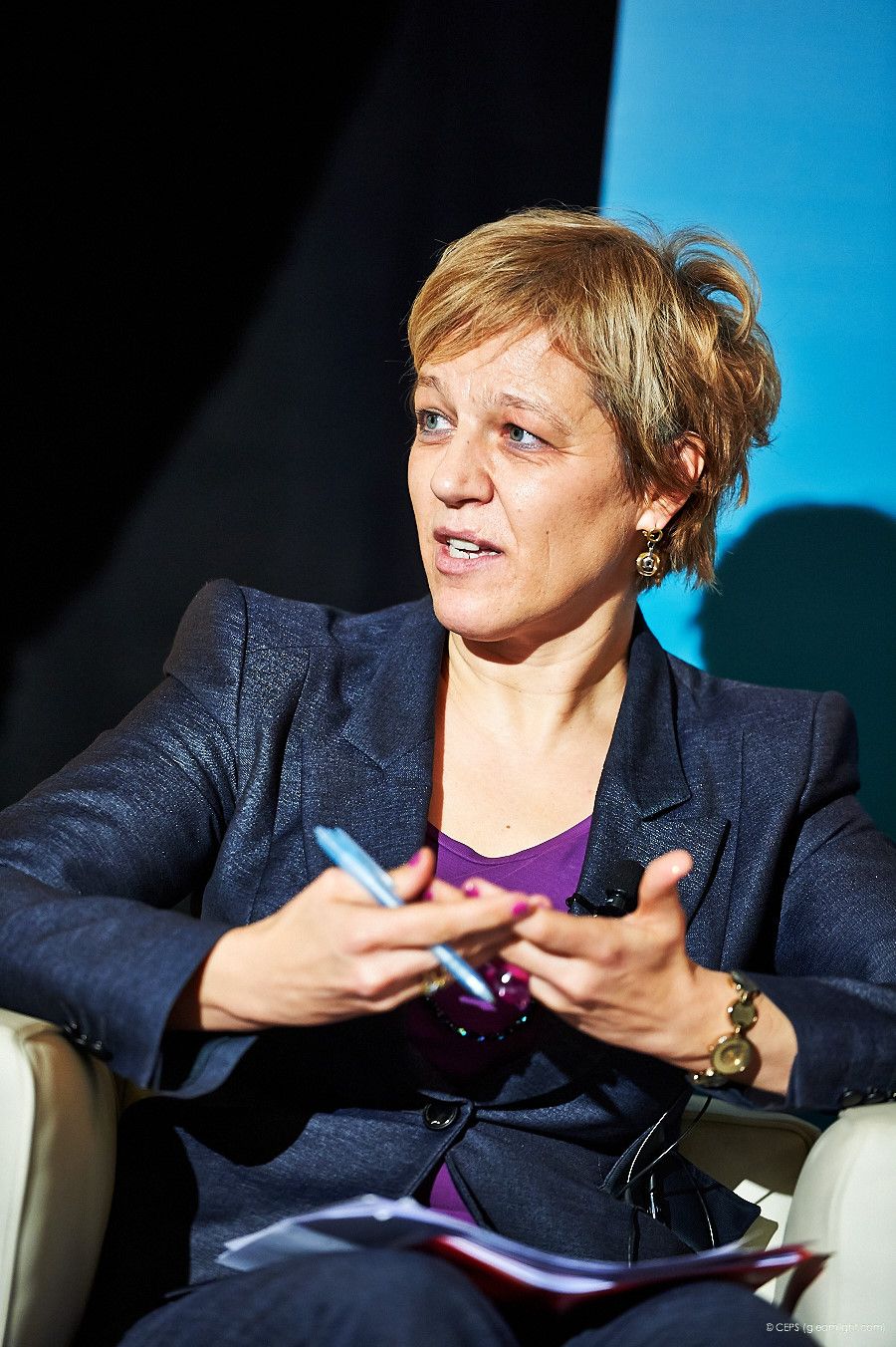 Speaker gesturing while presenting at a professional conference event.