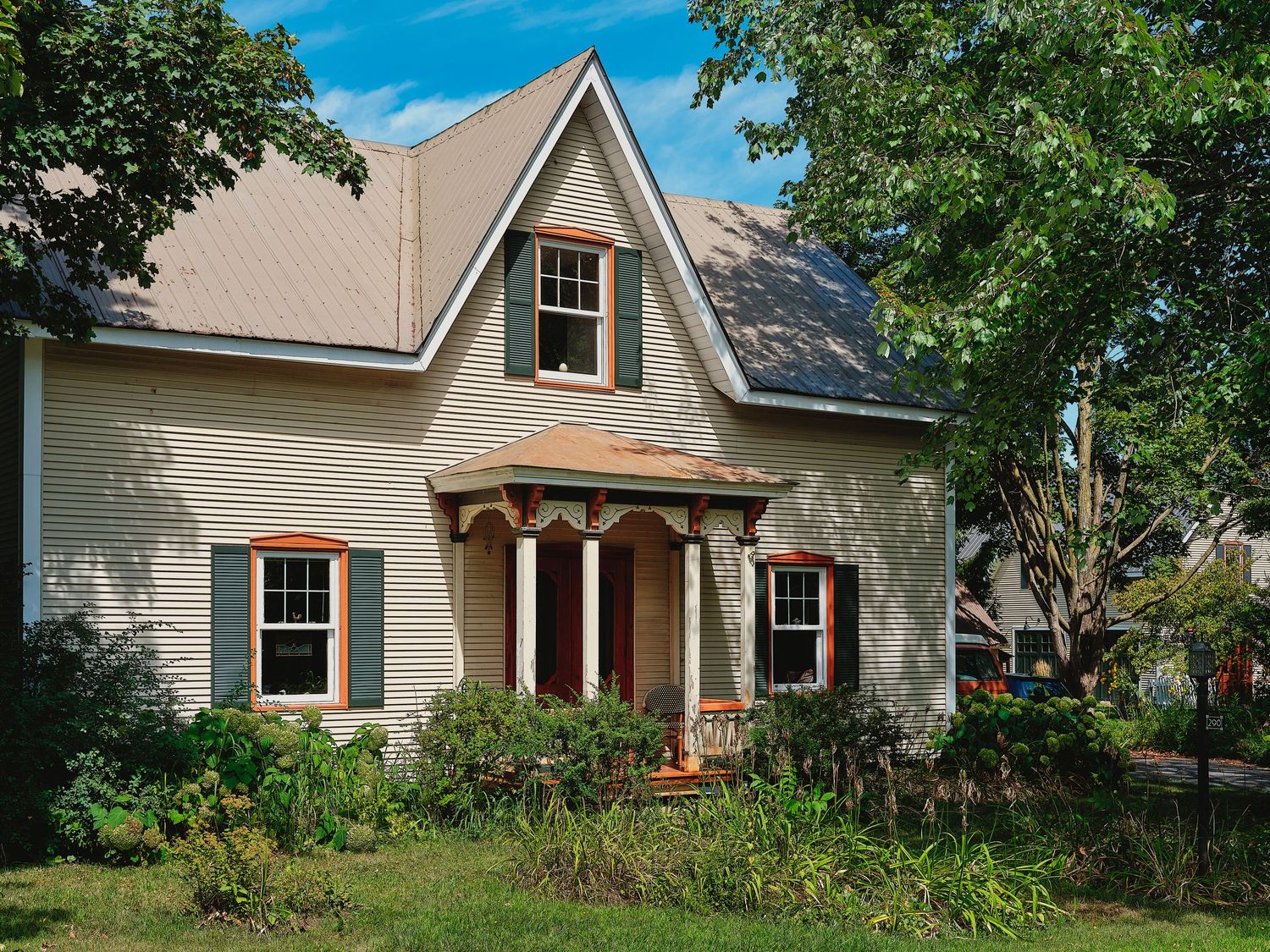 Row of traditional New England style houses with peaked roofs and porches along a residential street.