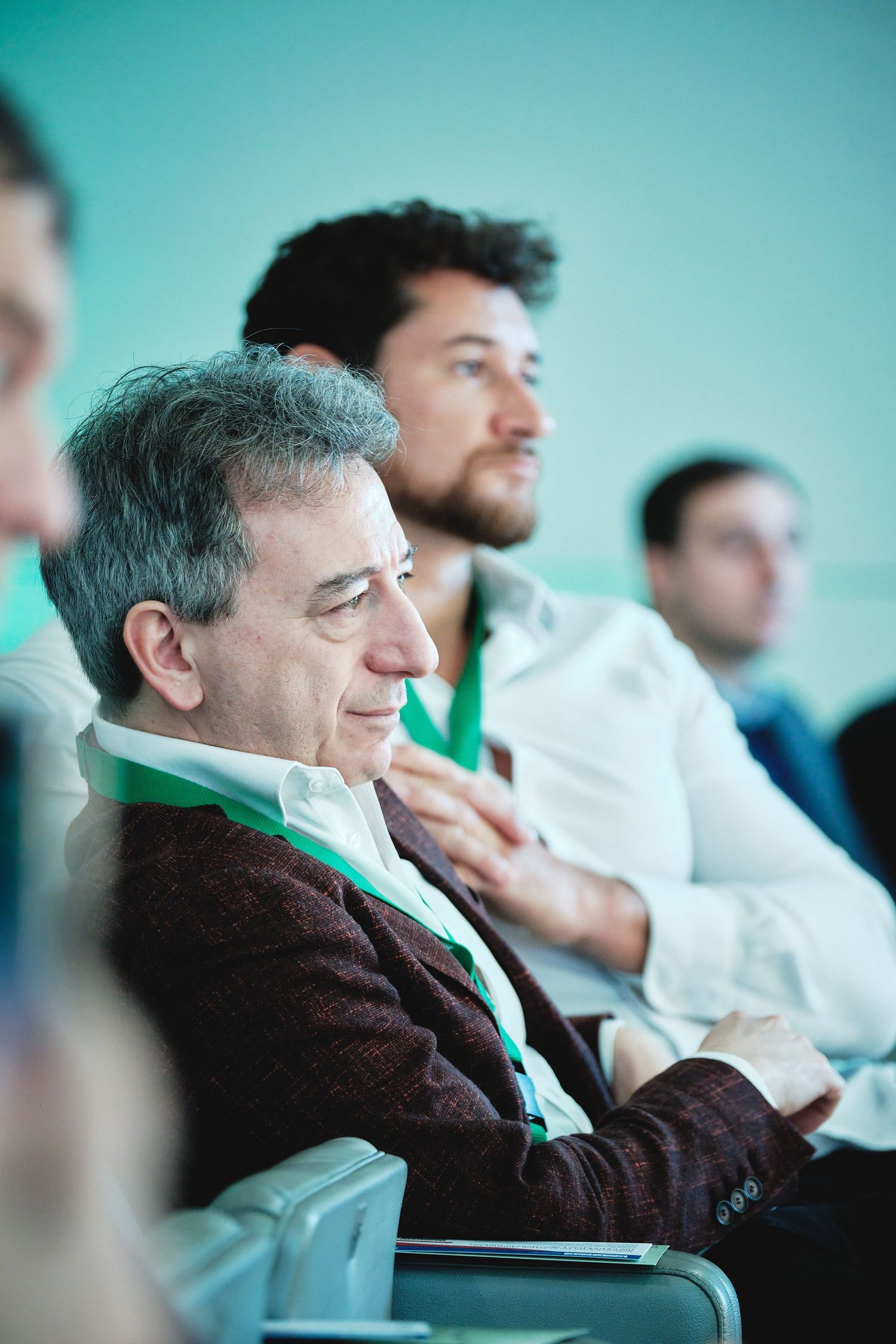 Conference attendees seated and listening attentively during presentation.