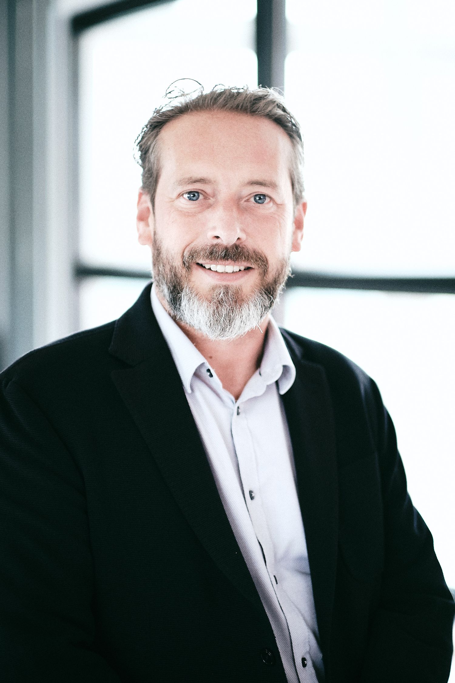 Professional headshots showing person in business attire with bright natural lighting.