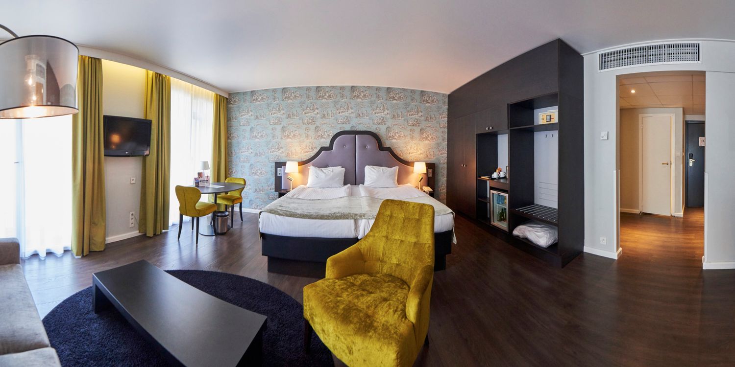 Luxury hotel bedroom featuring stylish decor and panoramic city views.