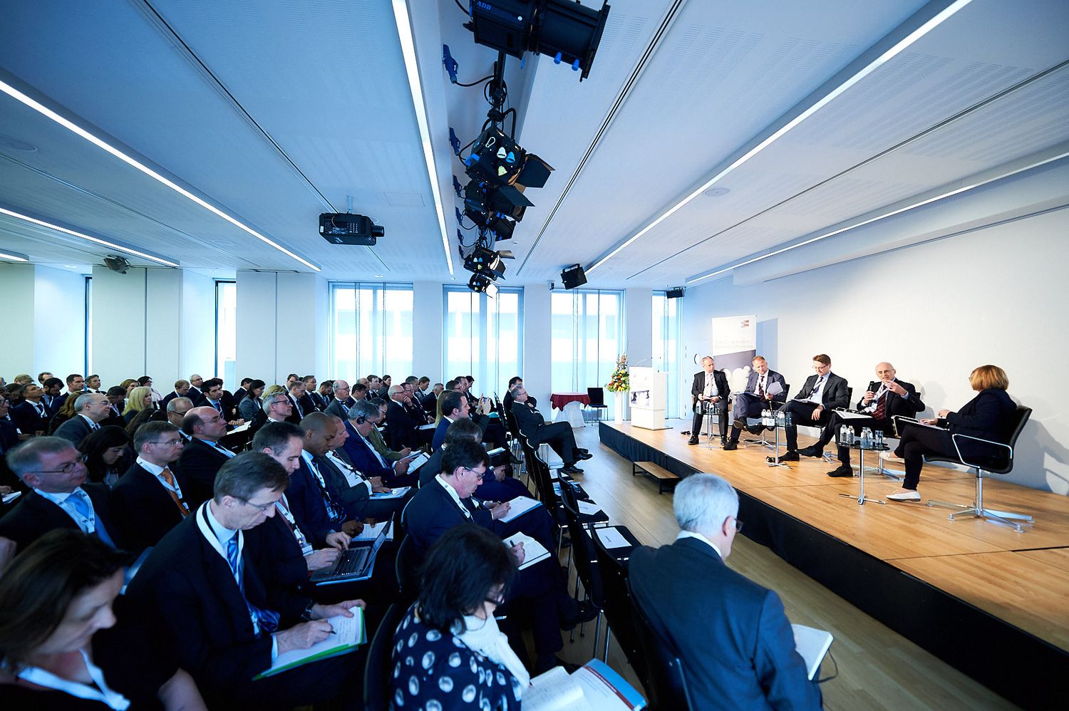 Wide angle view of modern conference room with attendees during business presentation.