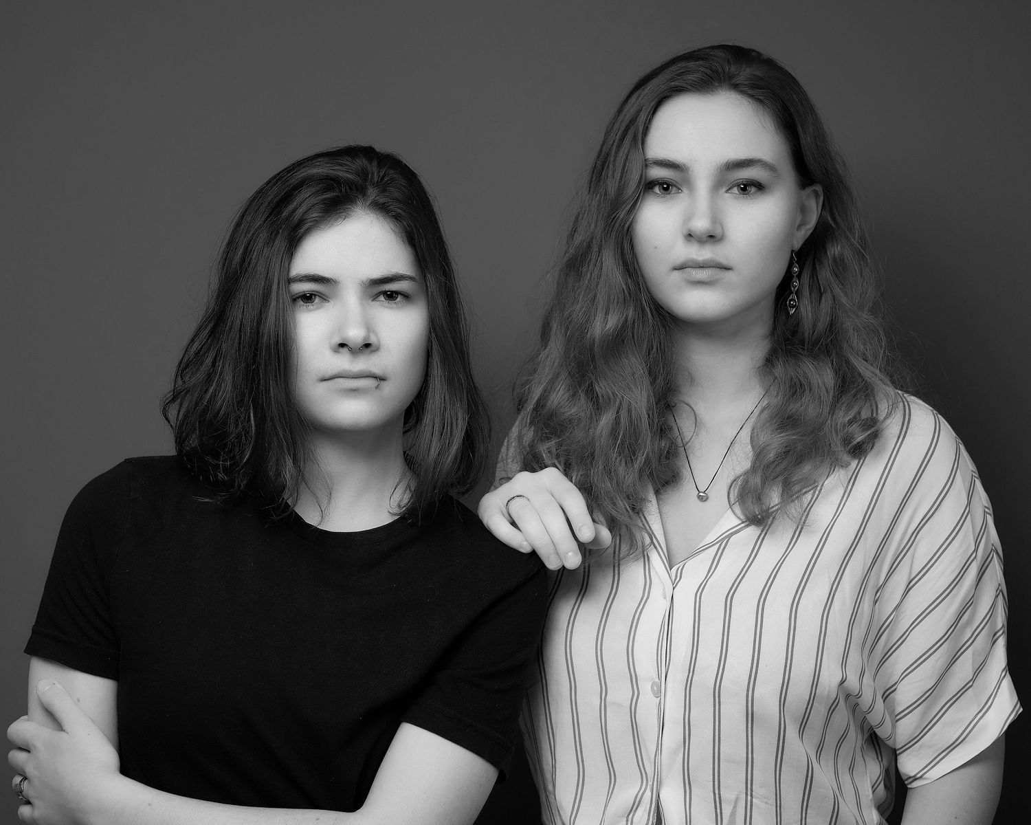 Black and white studio portraits showing two people in contrasting outfits.