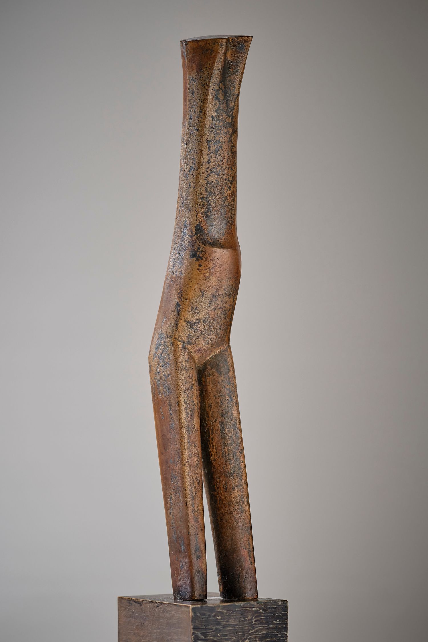 Rustic wooden sculpture of a standing figure mounted on a dark base.
