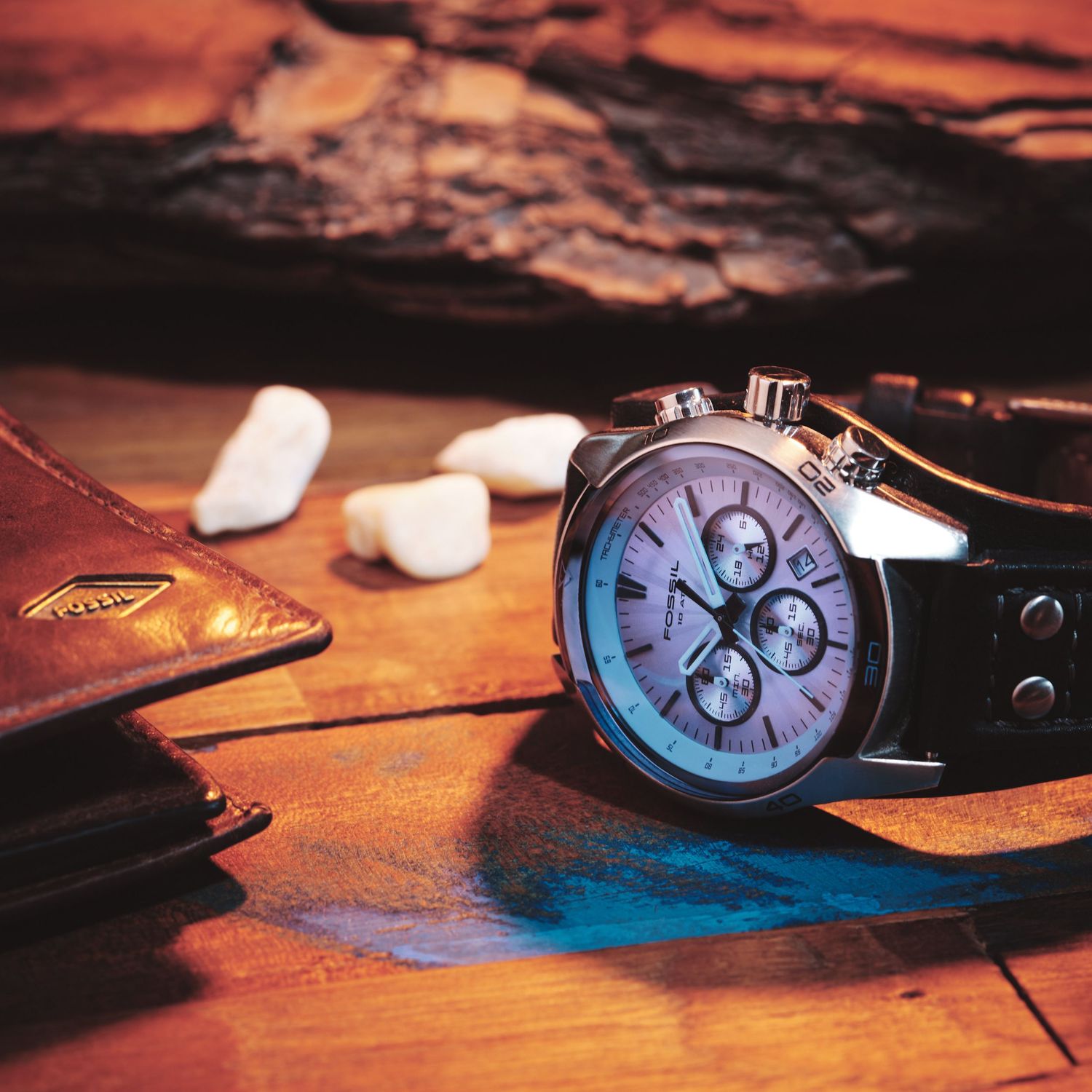 Elegant wristwatch with chronograph dials photographed on a wooden surface.