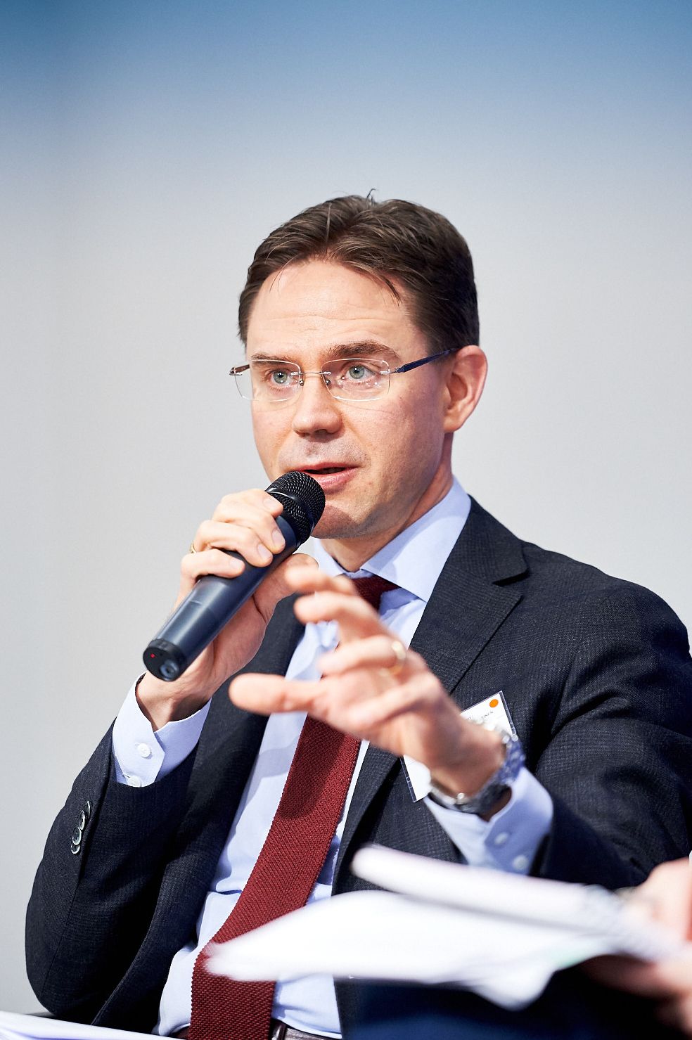 Business speaker gesturing while presenting at corporate event.