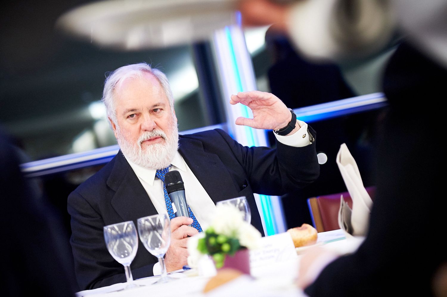 Professional speakers at a conference table during a business presentation.