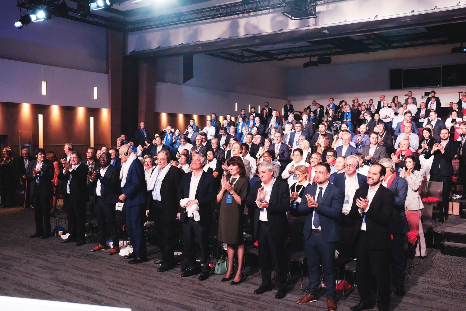 Large group of formally dressed attendees standing together at a professional conference event.