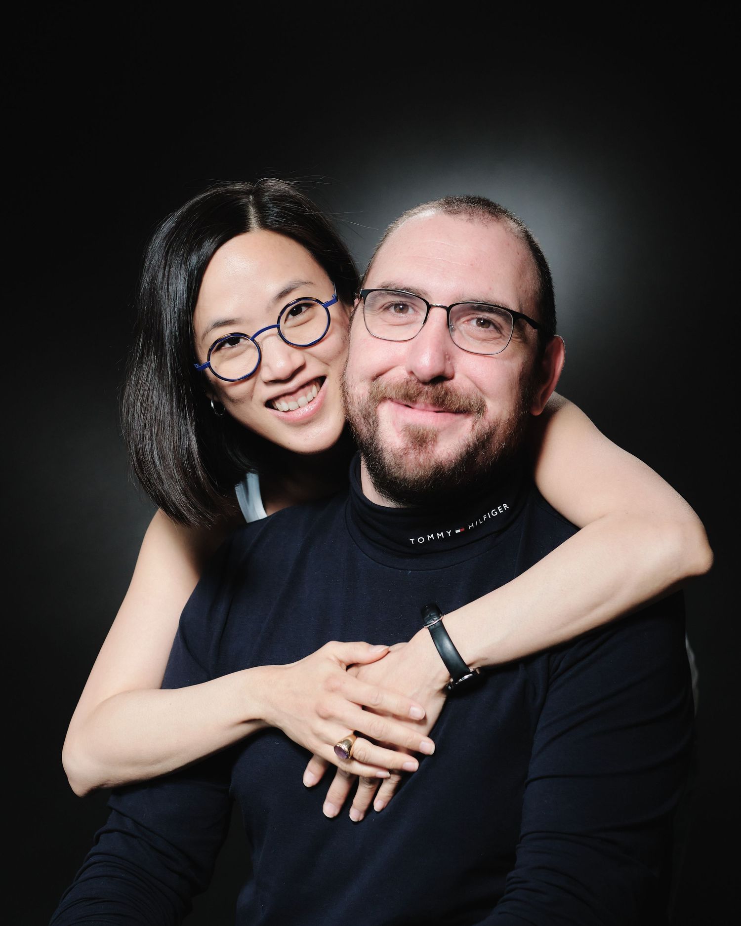 Playful studio portraits showing joyful family moments against dark background.