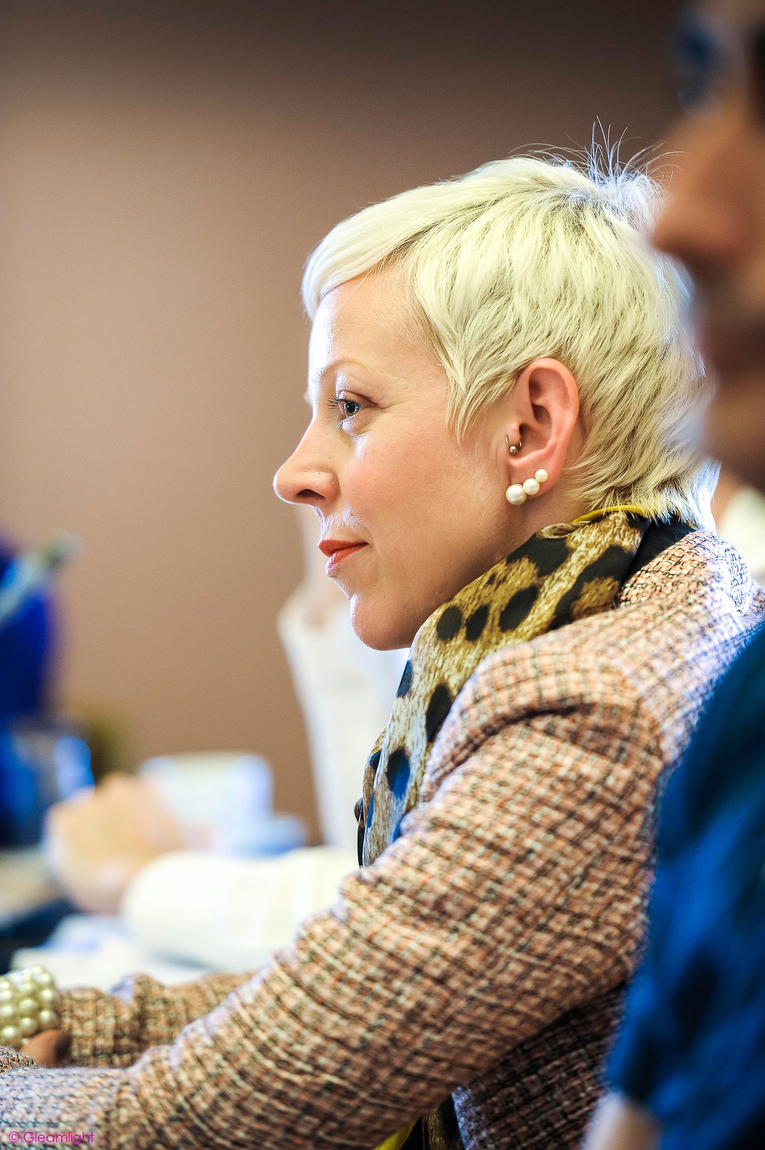 Professional in a tweed jacket attending a business conference.
