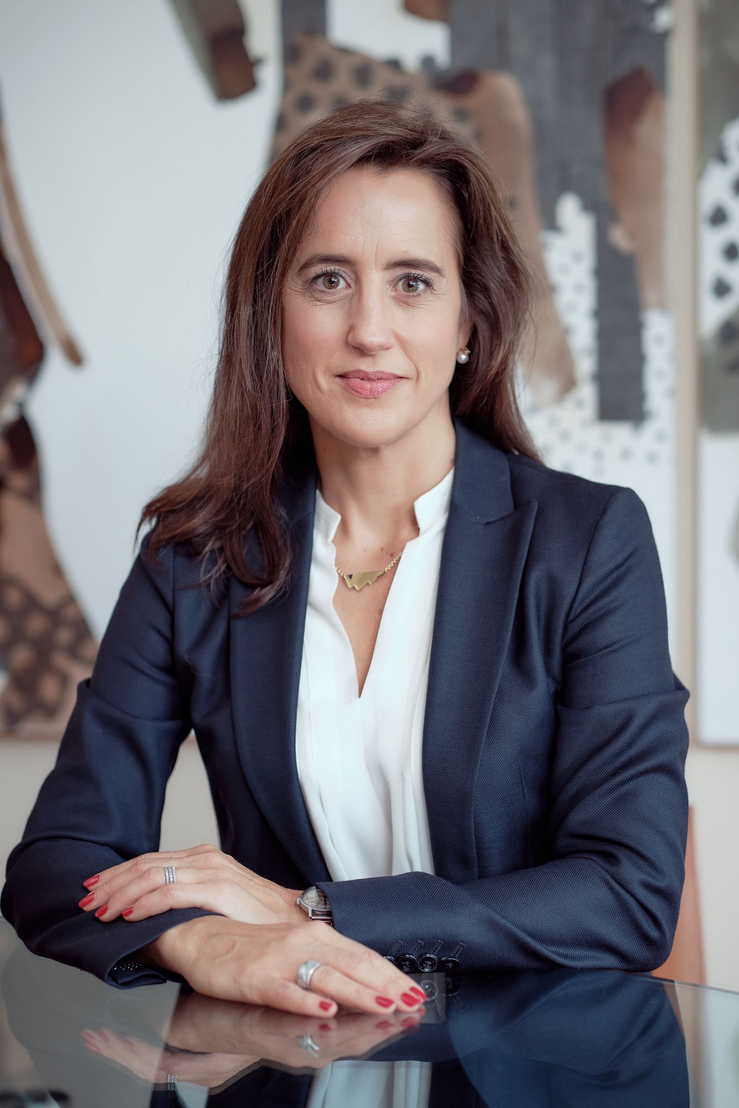 Professional headshots in navy blazer and white blouse against light background.