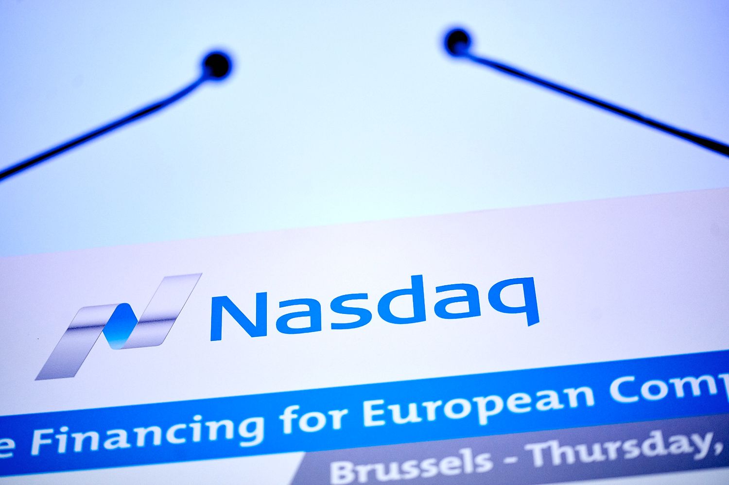 Nasdaq corporate logo and text displayed on a blurred business document header.