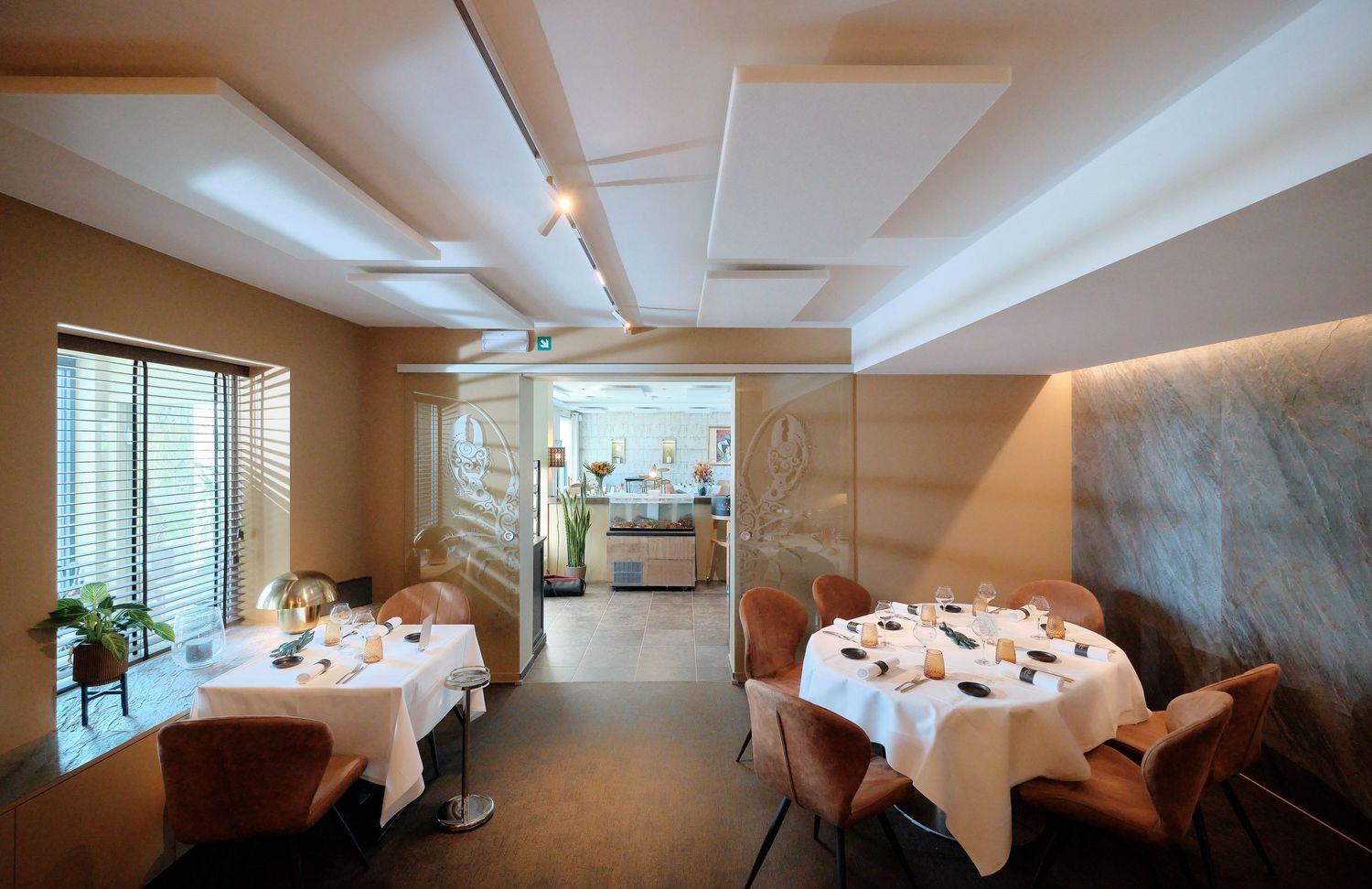 Elegant dining room with multiple round tables set for fine dining service.