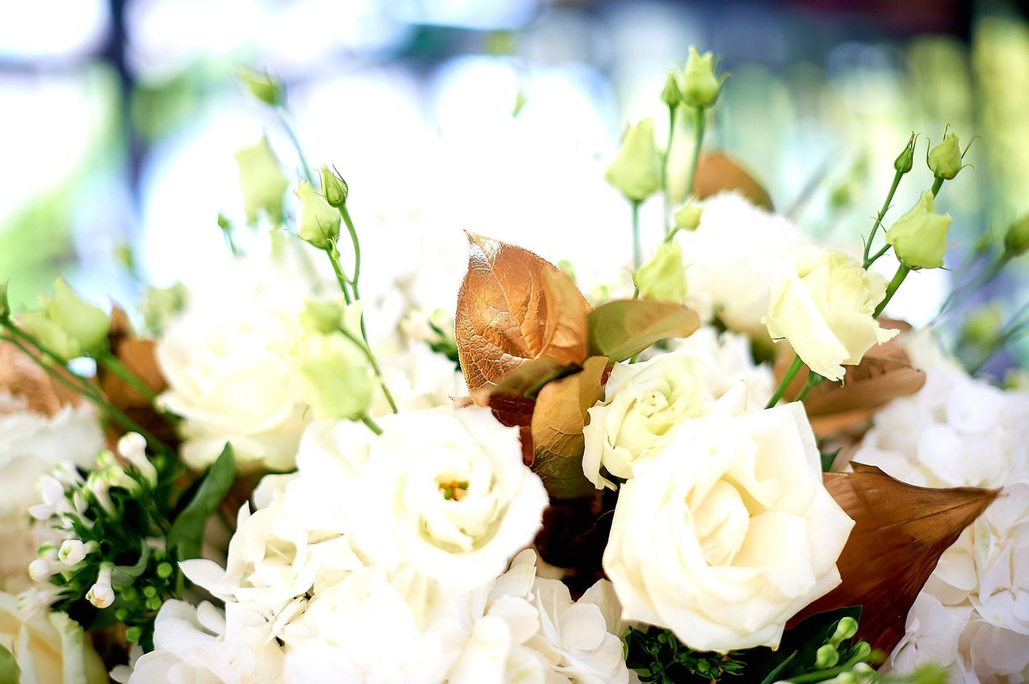 Elegant white roses and cream flowers bouquet with golden accents, perfect for weddings or special occasions.