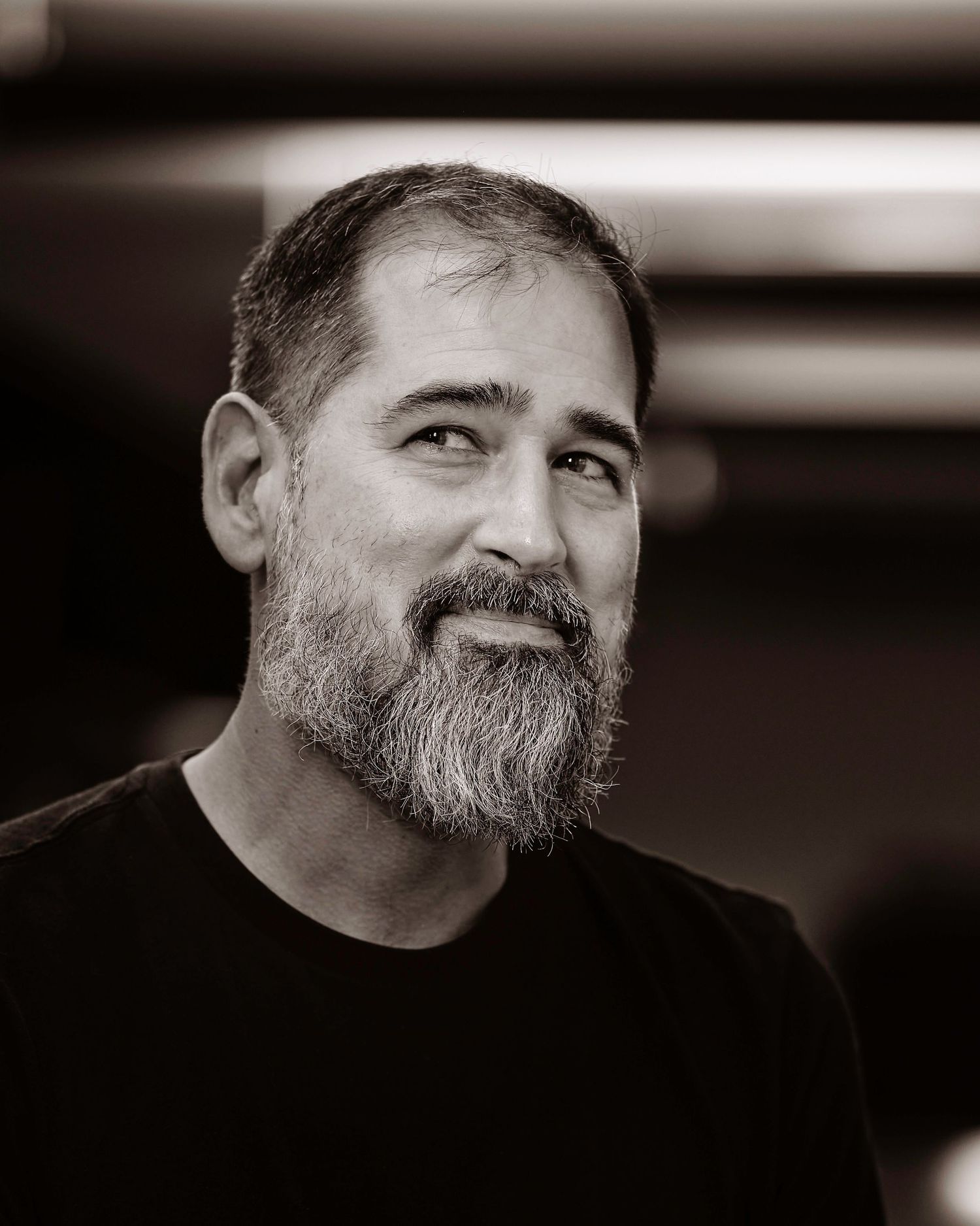 Black and white portrait series showing person with full beard in casual attire.