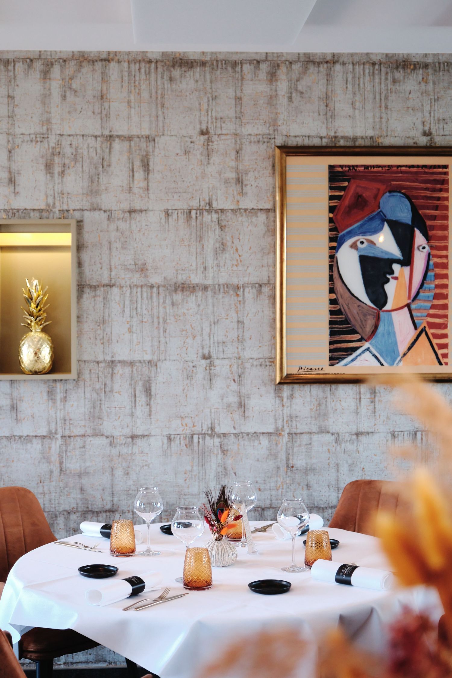 Contemporary restaurant wall featuring modern artwork and illuminated display niches above dining tables.