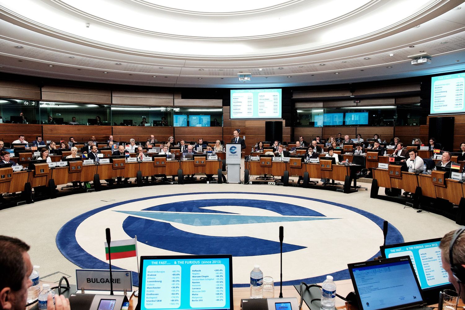 Panoramic view of a corporate meeting space with curved ceiling design and circular lighting fixtures.