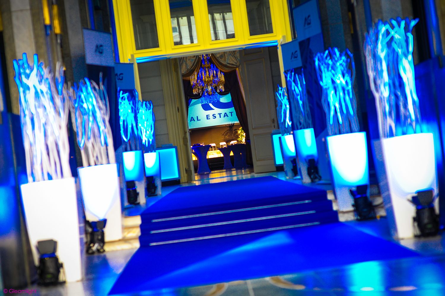 Event space illuminated with dramatic blue lighting and yellow accents.