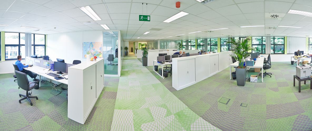 Open concept office space with green accents and modern workstations.